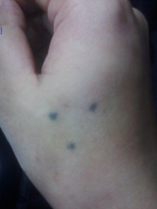 手に３つの点のタトゥー