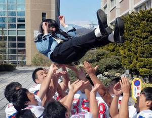 九州大学の合格発表でセーラー服の女子高生が胴上げされる