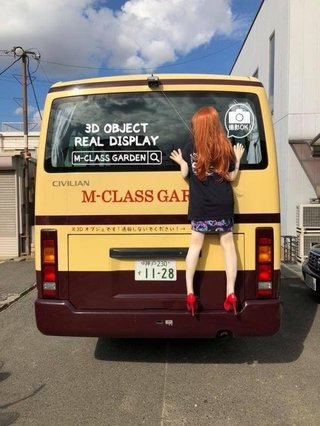 クルマの後ろに女の人形を貼り付けてる車